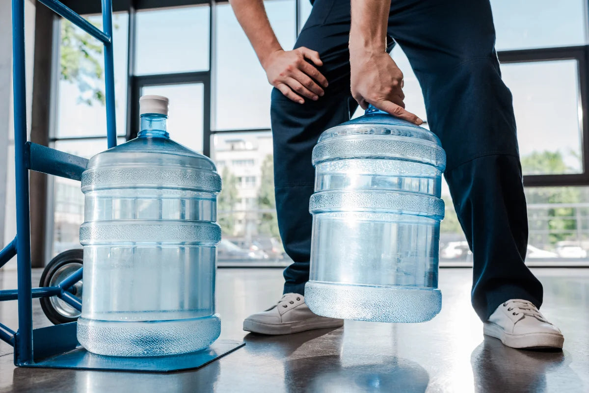 Hydronova-bezorger met twee flessen bronwater van 19 liter